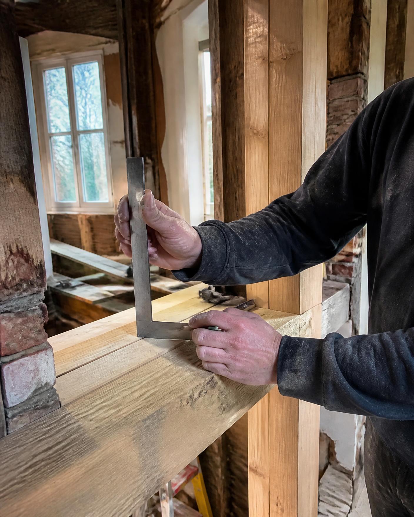 A joiner marking out timber during a house renovation